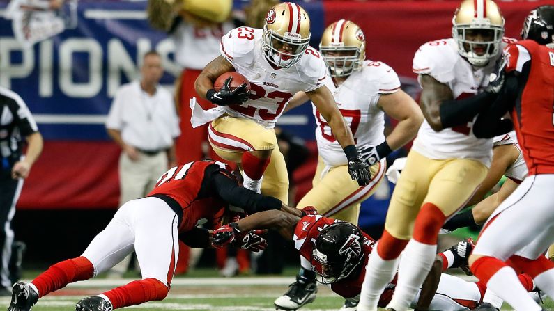 LaMichael James of the San Francisco 49ers leaps over Falcons defenders during a kick return in the first half.