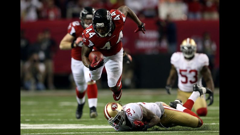 Jason Snelling of the Atlanta Falcons flies in the air over Dashon Goldson of the San Francisco 49ers.