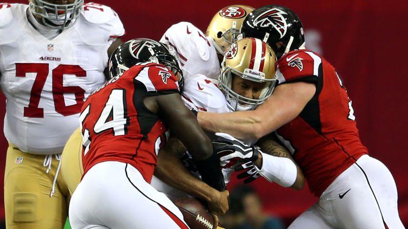 Quarterback Colin Kaepernick of the San Francisco 49ers is tackled by Stephen Nicholas, left, and Kroy Biermann of the Atlanta Falcons.