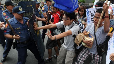 Activists in Manila scuffle with police Saturday after a U.S. Navy ship became grounded on a reef off the Philippines.