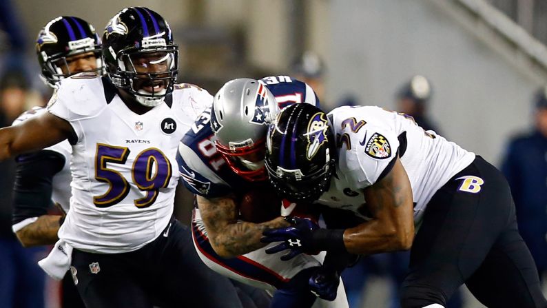 Aaron Hernandez of the Patriots gets tackled by Ray Lewis of the Baltimore Ravens.