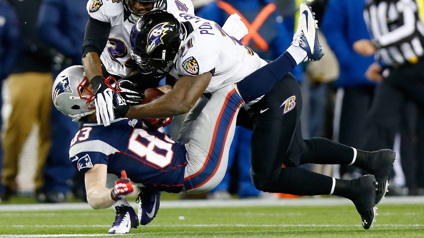 Wes Welker of the New England Patriots is tackled by Bernard Pollard and Corey Graham of the Baltimore Ravens after catching a pass.