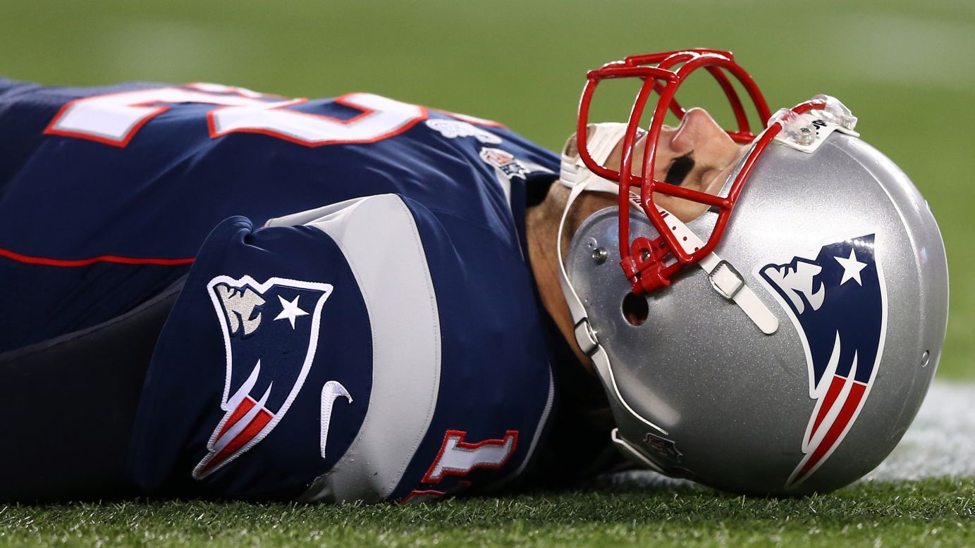 Patriots quarterback Tom Brady lays on the ground after getting knocked down in the fourth quarter.