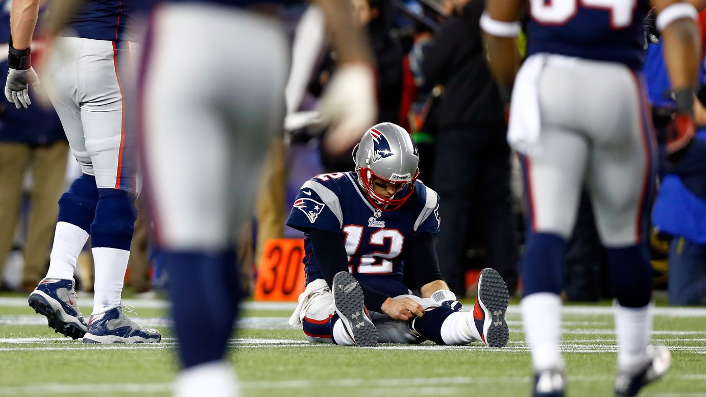 Tom Brady of the Patriots sits on the ground after getting knocked down in the game against the Ravens.