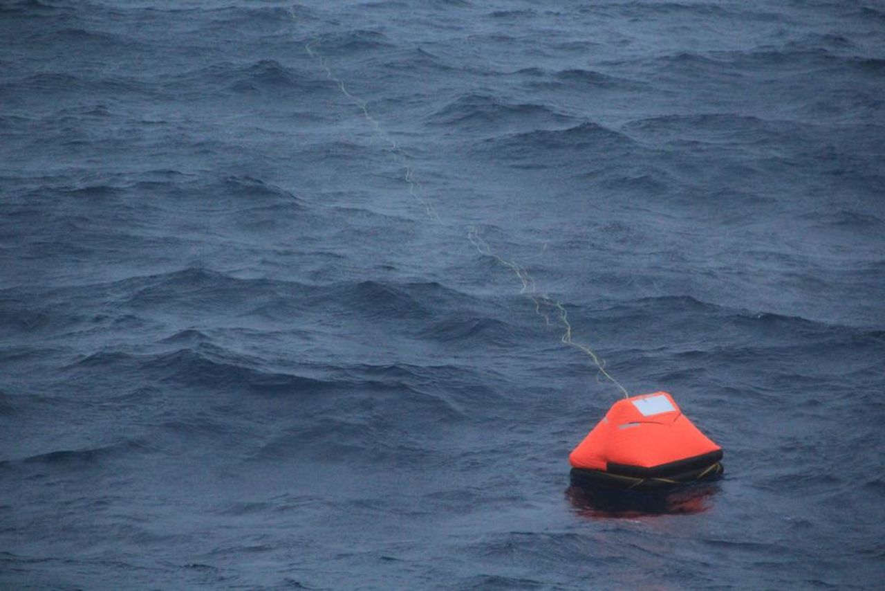 Alain Delord's life raft is pictured adrift in seas south of Australia and shortly before his rescue by the cruise ship Orion