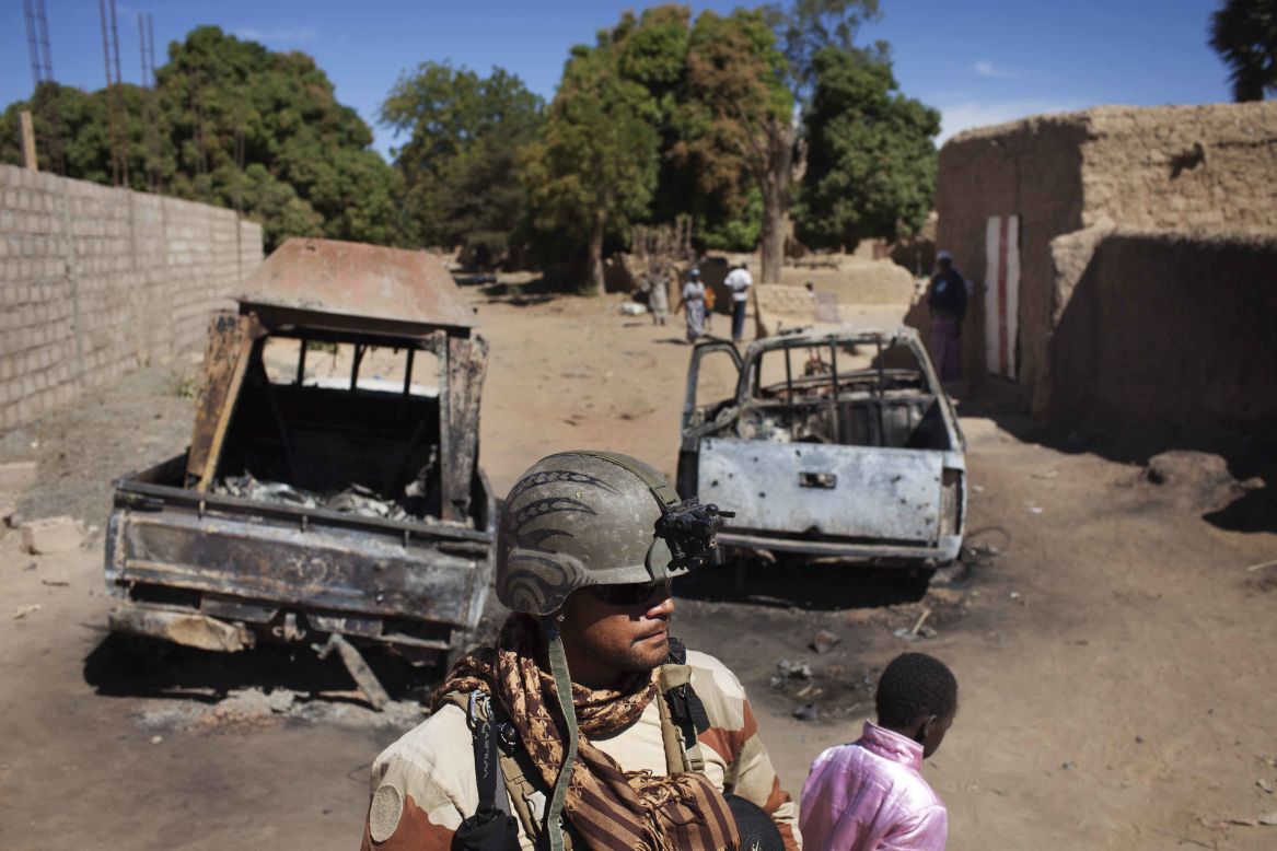 A French soldier stands guard in front of charred pickups used by Islamist rebels in Diabaly, Mali, on Monday, January 21. The Malian military says it has gained control of the town of Diabaly, a key advance in the battle against Islamist militants in the north.