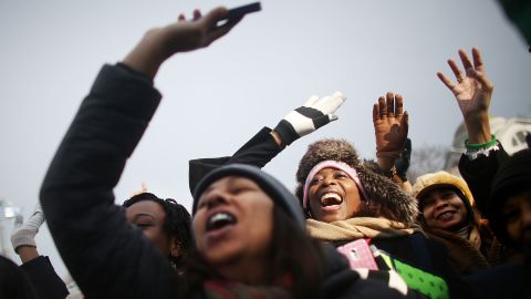 People cheer at a television camera on the National Mall before the inauguration ceremony Monday in Washington.