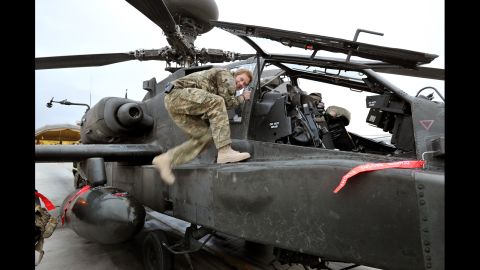 Harry climbs on board an Apache helicopter as part of a preflight check on December 12, 2012.