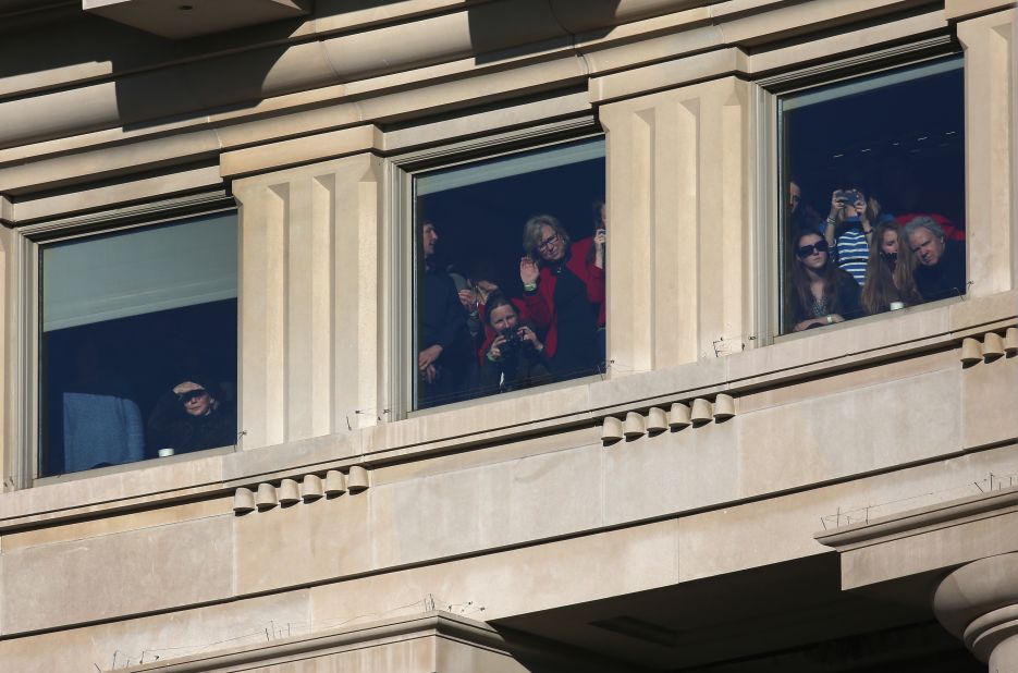 People watch as President Barack Obama and first lady Michelle Obama are driven past crowds during the Inauguration parade on Monday, in Washington. President Obama was sworn in for a second term office at the U.S. Capitol building. 