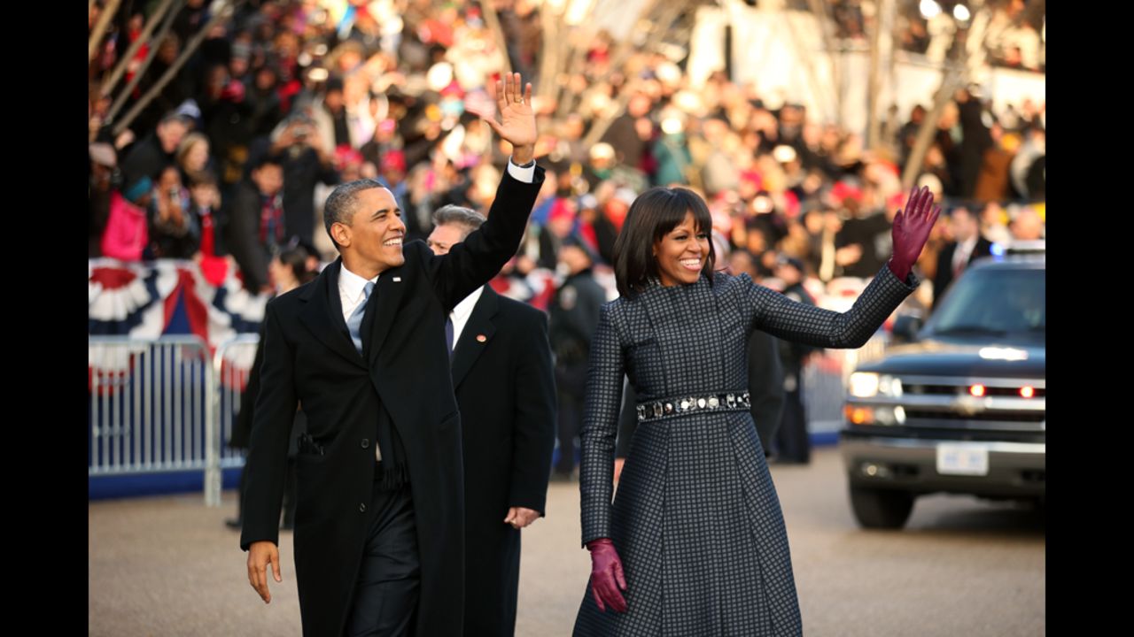 President Barack Obama and first lady Michelle Obama wave to the crowd as they make their way along the parade route on Monday.