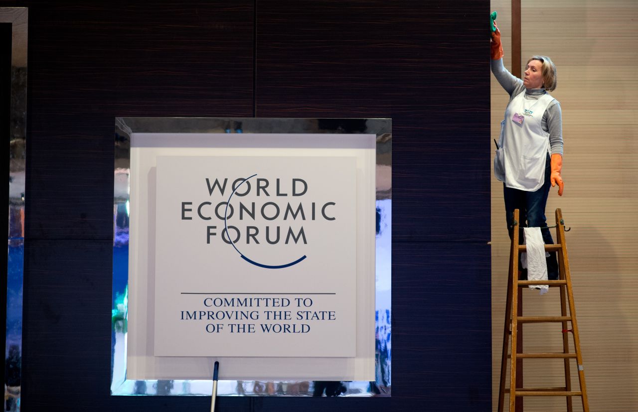 A woman cleans a logo of the World Economy Forum at the congress center on January 21, 2013 at the Swiss resort of Davos.