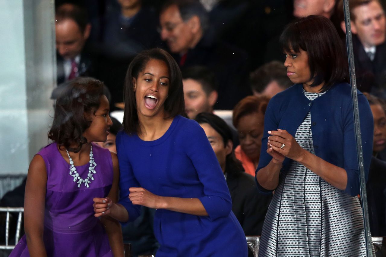 Malia Obama, center, dances on the reviewing stand while her sister Sasha Obama and first lady Michelle Obama look on as the the presidential inaugural parade winds through the nation's capital on Monday, January 21, in Washington.