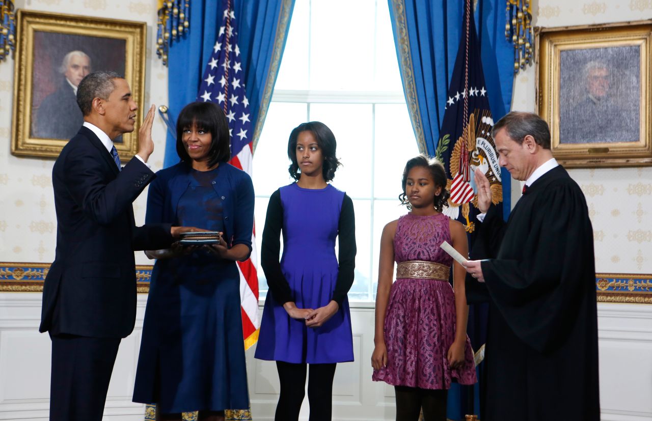 President Obama takes the oath of office from U.S. Supreme Court Chief Justice John Roberts as first lady Michelle Obama holds the bible and their daughters Malia, center, and Sasha look on in the Blue Room of the White House in Washington, on Sunday, January 20.