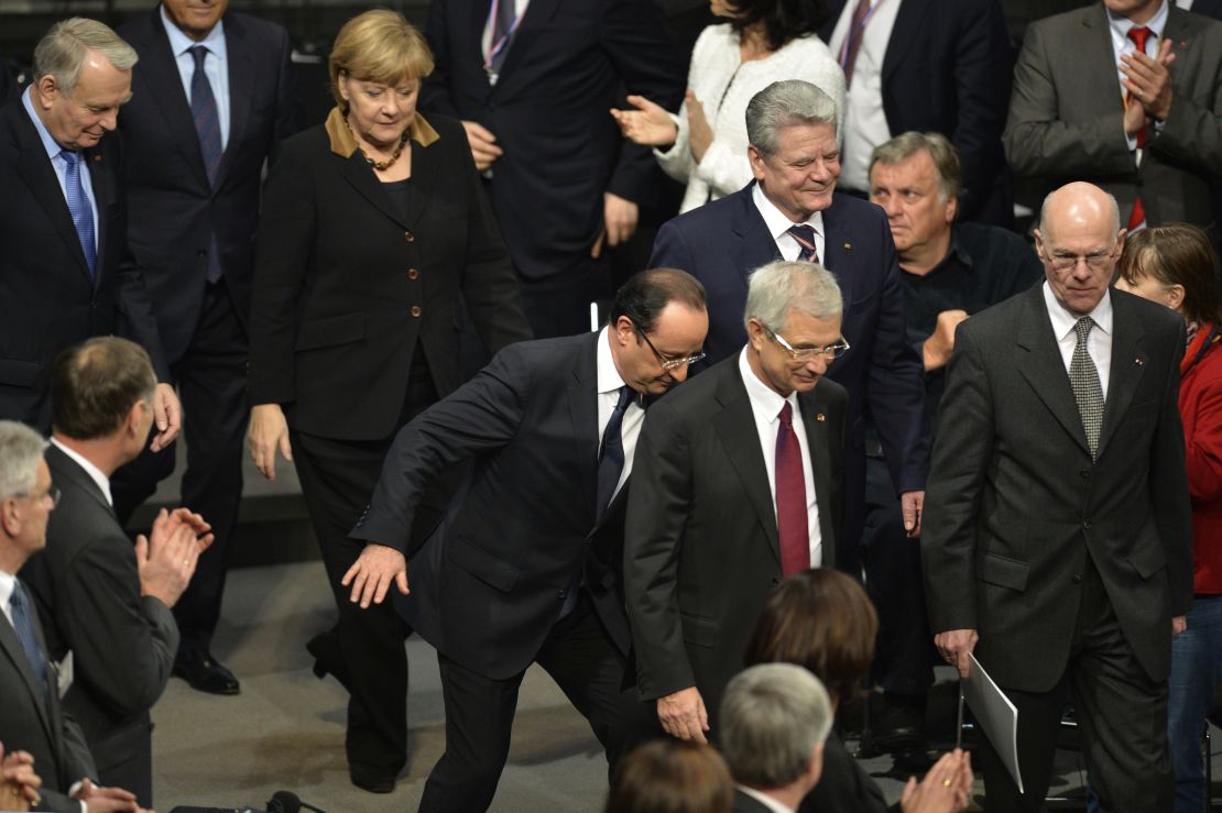 French President Francois Hollande stumbles as he arrives at the Reichstag with German Chancellor Angela Merkel.