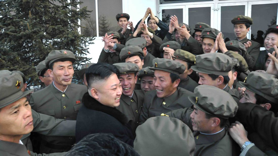 In a photo released by the official North Korean news agency in December 2012, Kim celebrates a rocket's launch with staff from the satellite control center in Pyongyang.