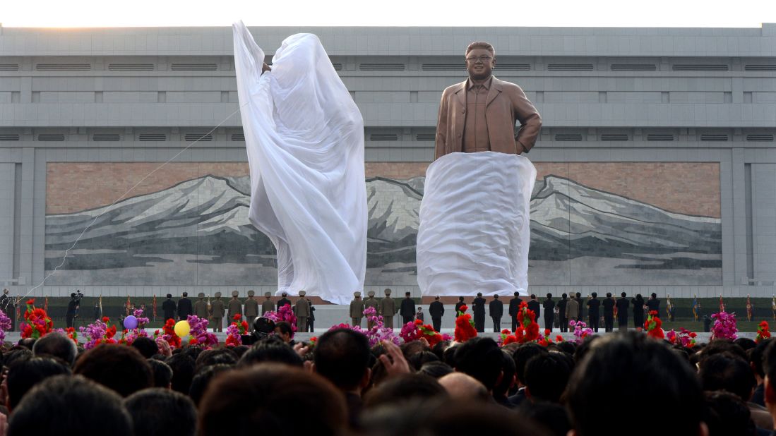 A crowd watches as statues of North Korean founder Kim Il Sung and his son Kim Jong Il are unveiled during a ceremony in Pyongyang in April 2012.