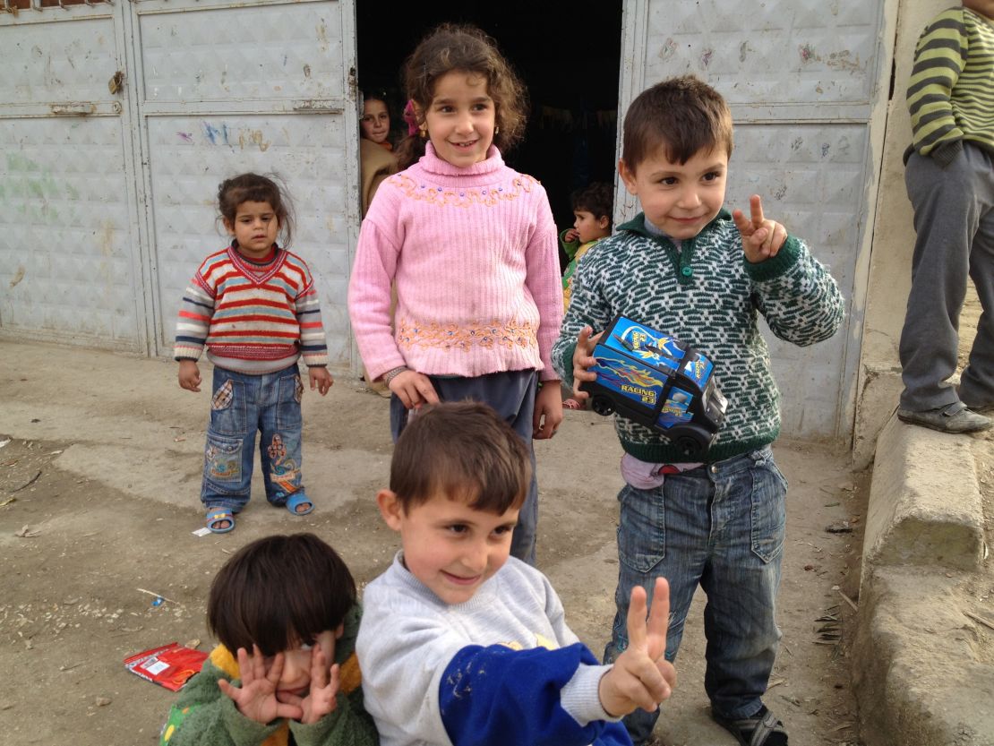 Children stand outside a building housing Syrian refugees in Hacipasa, Turkey.