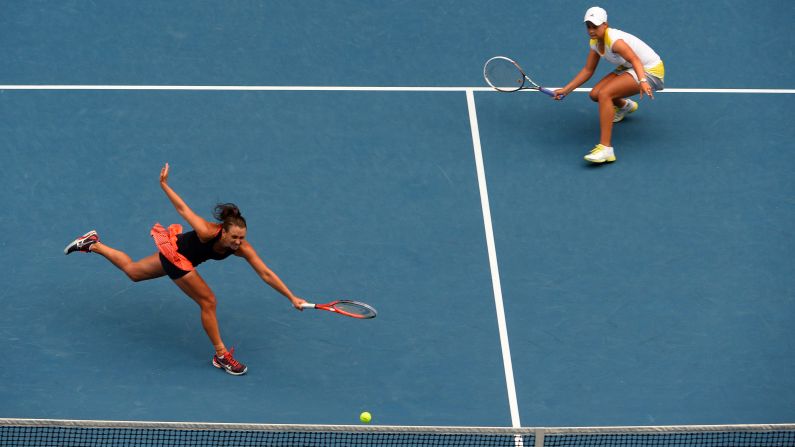 Ashley Barty of Australia, right, watches as compatriot Casey Dellacqua plays a return during their women's doubles final against Sara Errani and Roberta Vinci of Italy on day 12 of the Australian Open in Melbourne on Friday, January 25. The Italian pair beat Barty and Dellacqua 6-2, 3-6, 6-2.
