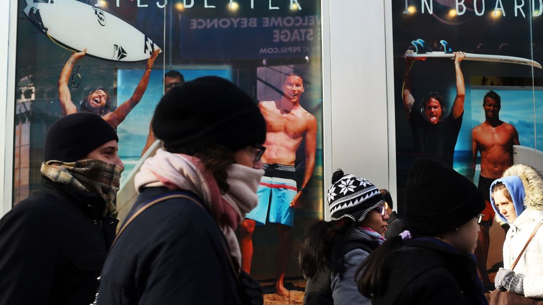 A surfer store with guys in swimwear seems an especially cruel sight for these bundled-up New Yorkers on Tuesday, January 22, as frigid temps hit the region. 