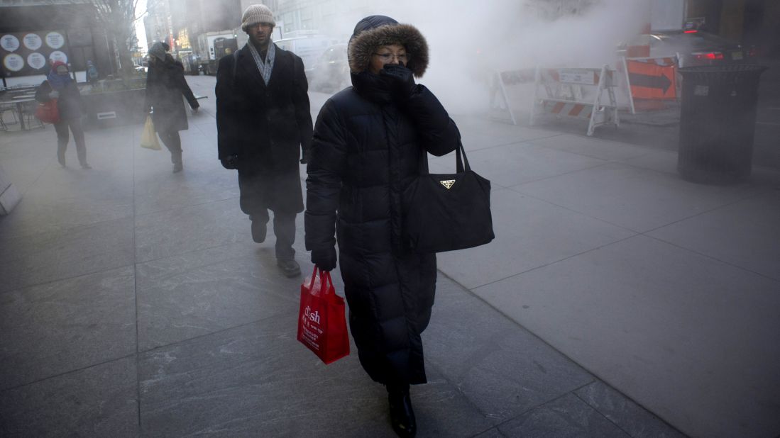 A woman keeps covered up as steam rises from the street on January 23 in New York.