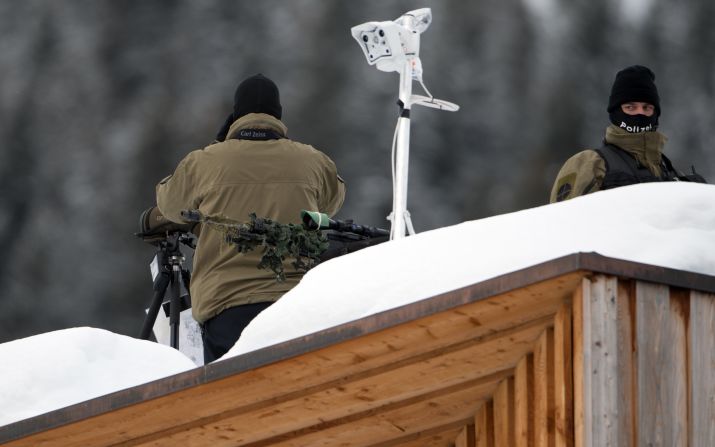 Policemen stand guard on the roof of the congress center in Davos. 
