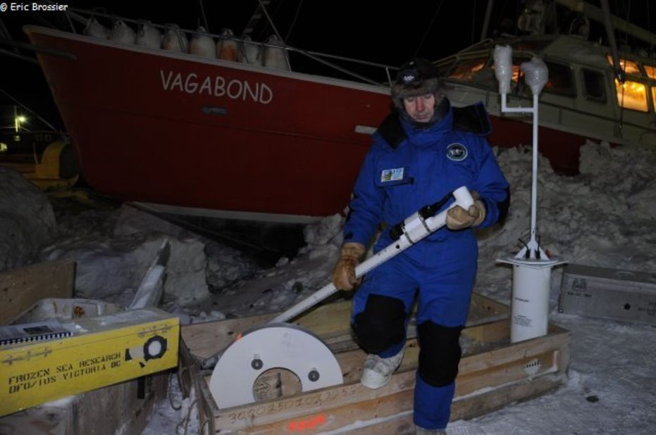 Eric Brossier prepares scientific equipment on the ice just outside Grise Fiord. Brossier's work sees him measure ocean currents, the density of sea ice and weather patterns across large areas of the Canadian Arctic.