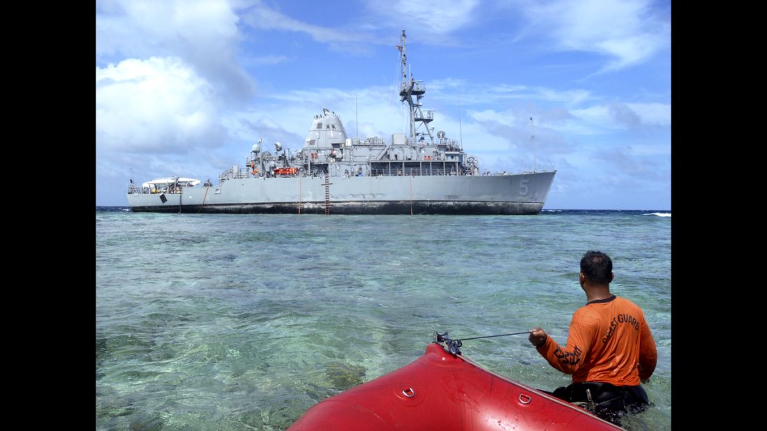 A member of the Philippines coast guard approaches the USS Guardian on Tuesday, January 22, in a handout picture from the Philippines coast guard.