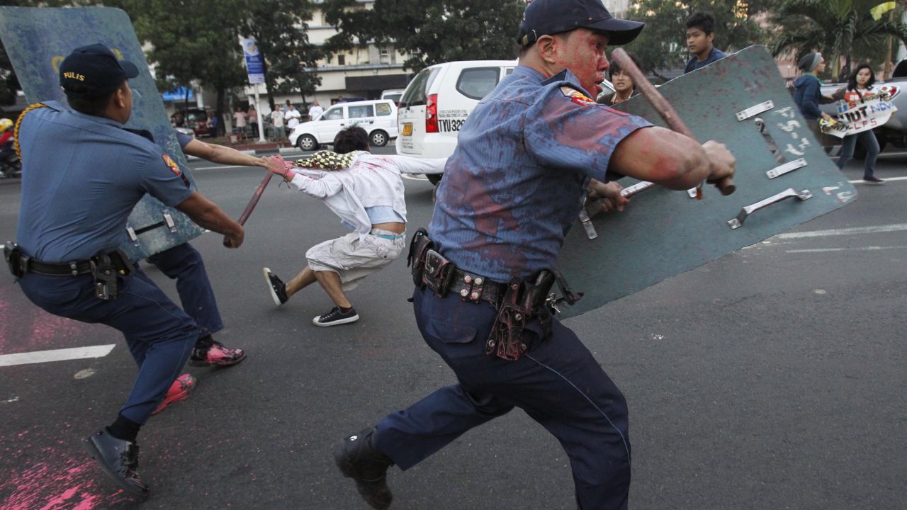 Anti-riot police disperse protesters in front of the U.S. Embassy in Manila on Friday, January 25. The Filipinos were demonstrating against the grounded U.S. Navy minesweeper and called for the pullout of American troops stationed in the Philippines. They splattered the police with paint.