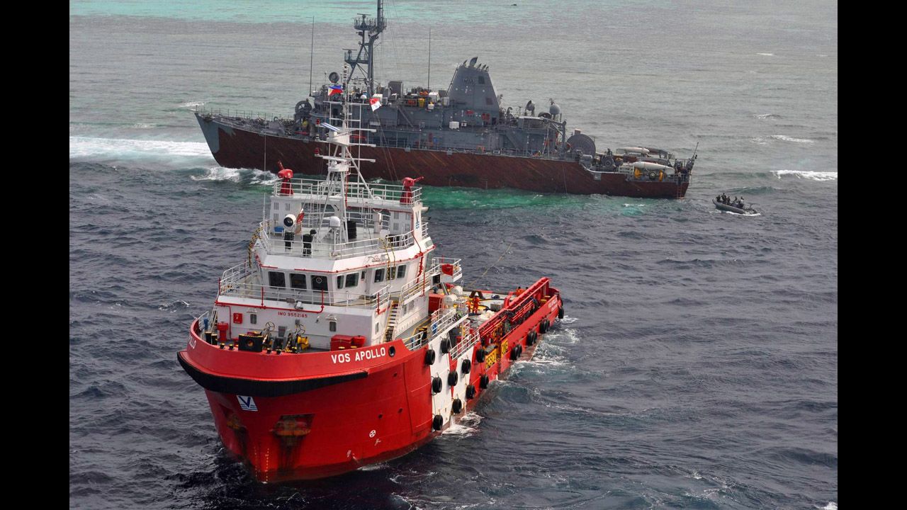 Malaysian tug Vos Apollo, foreground, prepares to help remove fuel from the USS Guardian while a U.S. Navy boat approaches with a salvage team on Thursday, January 24.