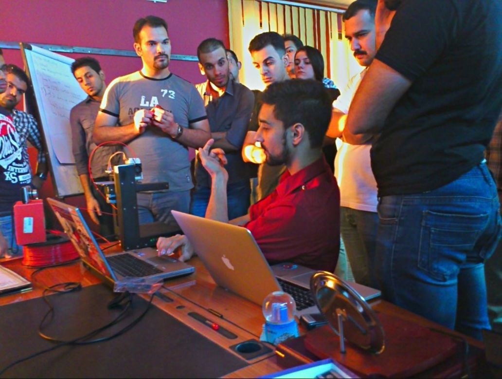Bilal Ghalib, an advocate of hackerspaces in the Middle East, models a 3D printer to members of Fikra Space.