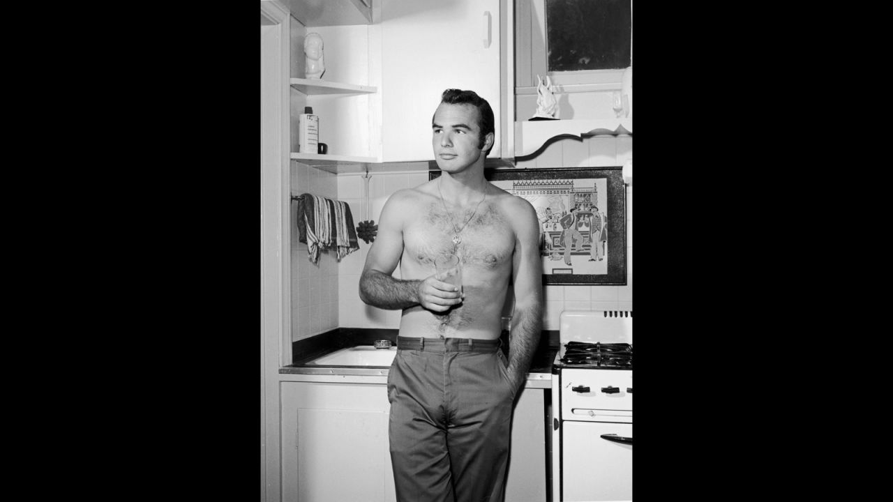 A bare-chested Reynolds stands on a kitchen set in 1960.
