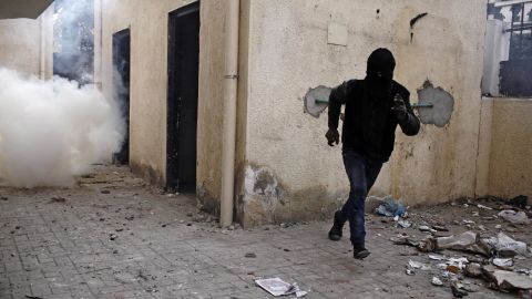 An Egyptian protester runs away from a cloud of tear gas fired by Egyptian riot police on January 26, in Cairo. 
