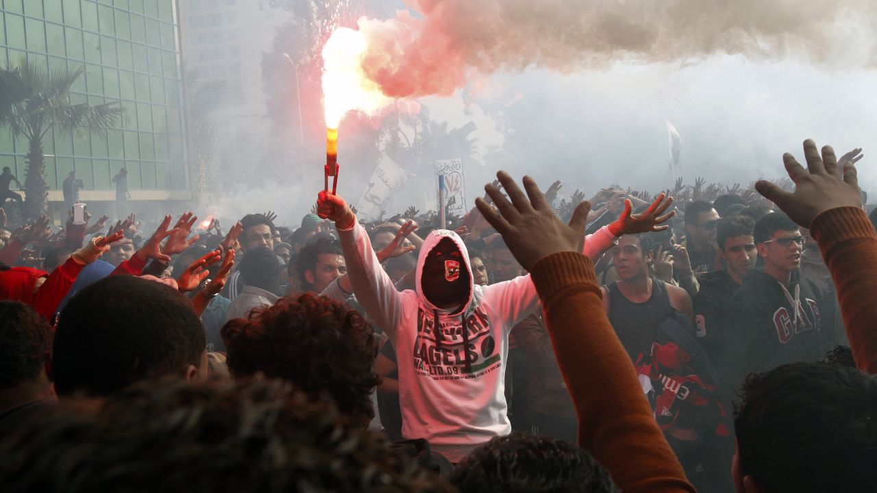 A fan of Al-Ahly football club lights a flare as club supporters celebrate outside its headquarters in Cairo on January 26.