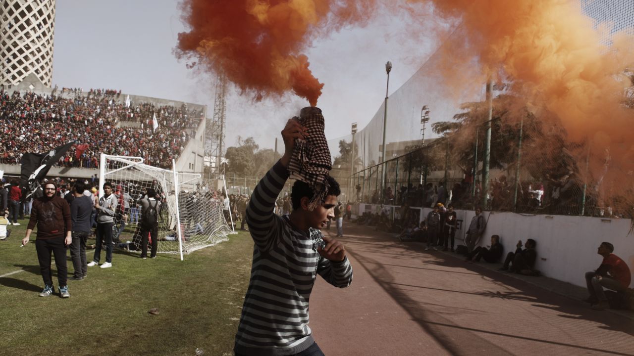 An "Ahly-Ultra" soccer fan holds a smoke flare above his head in Cairo.