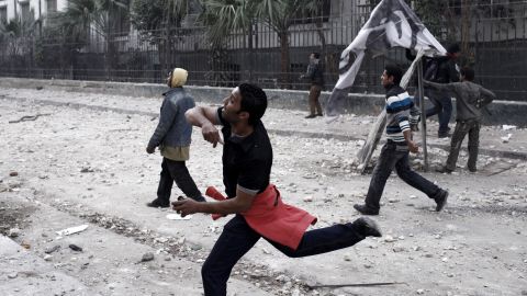 A protester throws a rock at riot police on January 26, in Cairo.