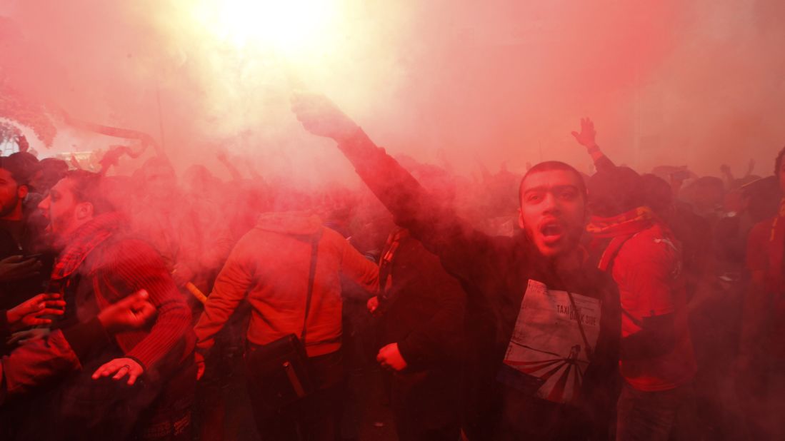 A fan of Al-Ahly football club lights a flare as club supporters celebrate on January 26 in Cairo.