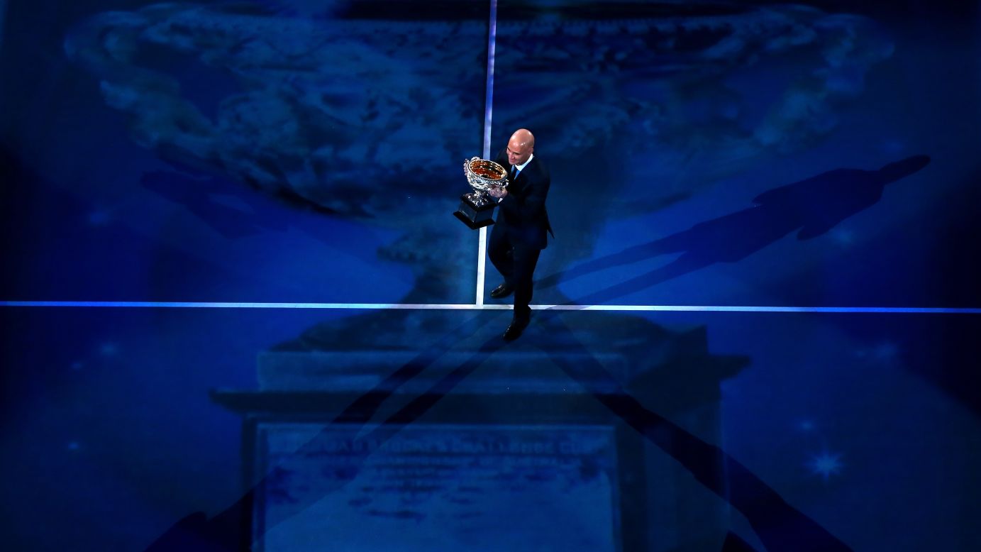 Four-time Australian Open men's singles champion Andre Agassi carries the Norman Brookes Challenge Cup before the men's final match on January 27.