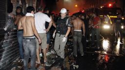 Several firefighters, onlookers and police officers surround a nightclub after a fire broke out inside in Santa Maria, Brazil, on January 27.