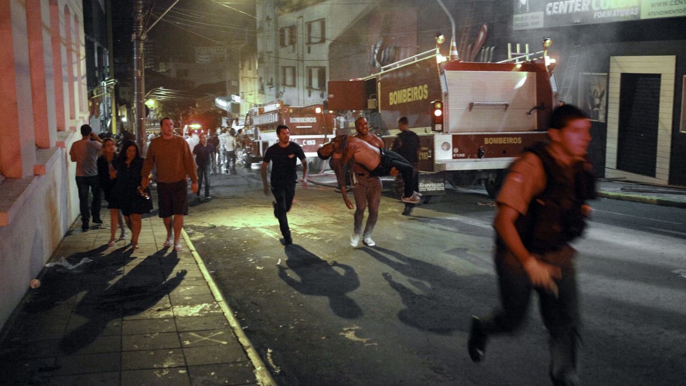 A firefighter, center, carries a victim away from the blaze.