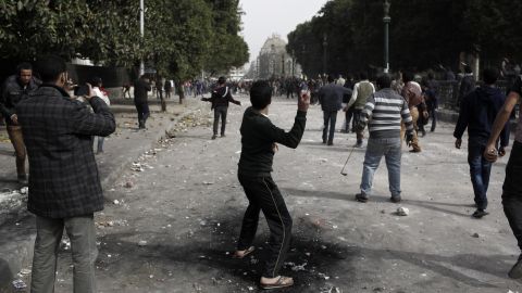 A protester throws a rock toward opposing demonstrators on January 27 in Cairo.