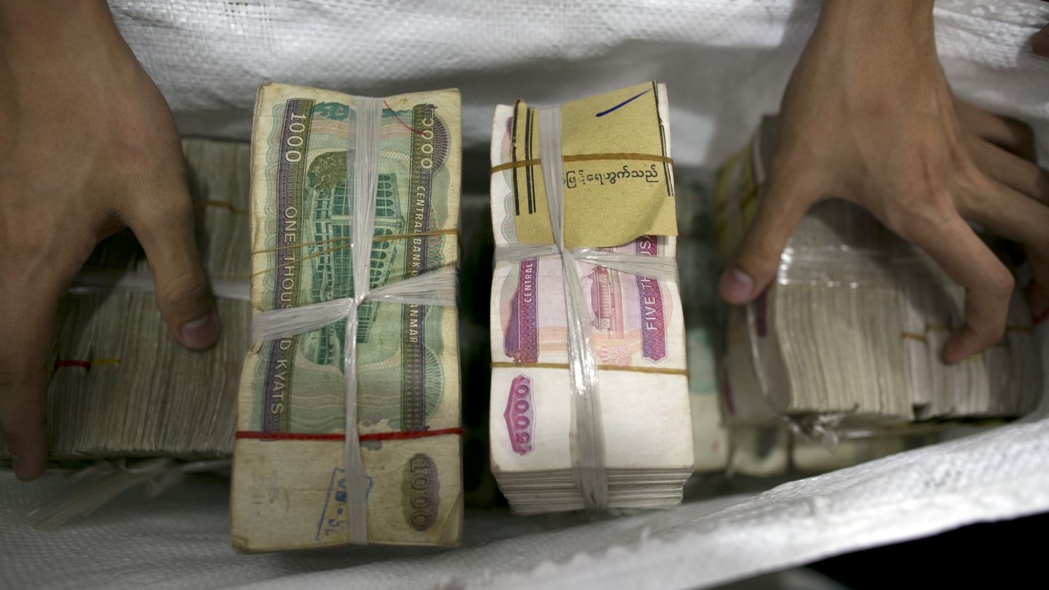 Burmese currency is put into a money bag at a bank in Yangon, Myanmar. 