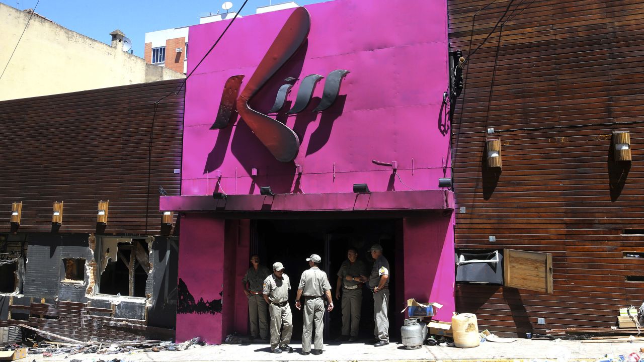 Firefighters stand at the burnt-out entrance of the Kiss nightclub on Sunday, January 27, in Santa Maria, Brazil.