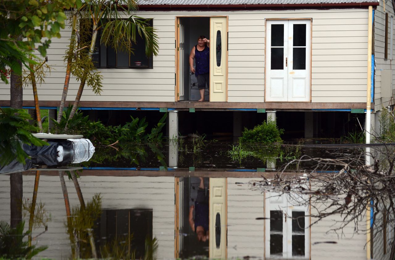 Geraldine Marino stands at her front door surrounded by floodwater on January 28 in Bundaberg.