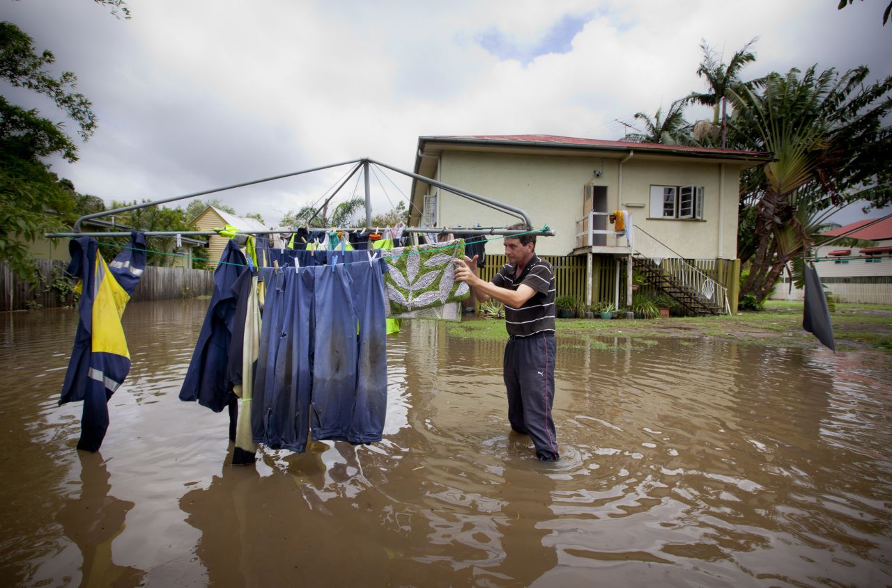 Tony Hall stands in floodwaters as he checks his washing on a clothesline on January 28 in Newmarket.