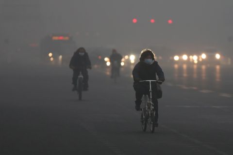 Beijing residents wear masks as they ride through the pollution on January 29.