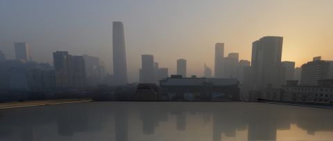 Air pollution hangs over the skyline as the sun rises over the central business district in Beijing on Monday, January 14.