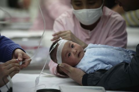 Nurses attend to a baby in the hospital for the flu in Beijing on Sunday, January 13. A Beijing pediatric hospital says it has treated a record 9,000 children this month for respiratory illnesses, most of which doctors and patients blame on the smog, Xinhua reported.