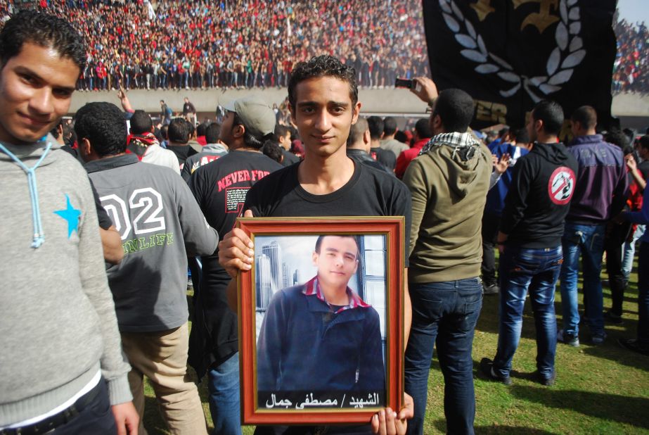Many of the victims' families were also there, holding pictures of loved ones. Here one young fan holds a portrait of his best friend, who died in Port Said.