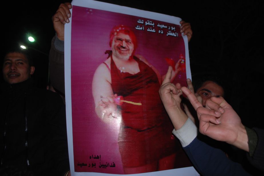 Meanwhile, in Port Said, the announcement sparked violence that led to the deaths of more than 30 people and the imposition of a curfew by President Morsy. A protest was organized to break the curfew. Here a protester carries a picture of Morsy blowing bubbles.