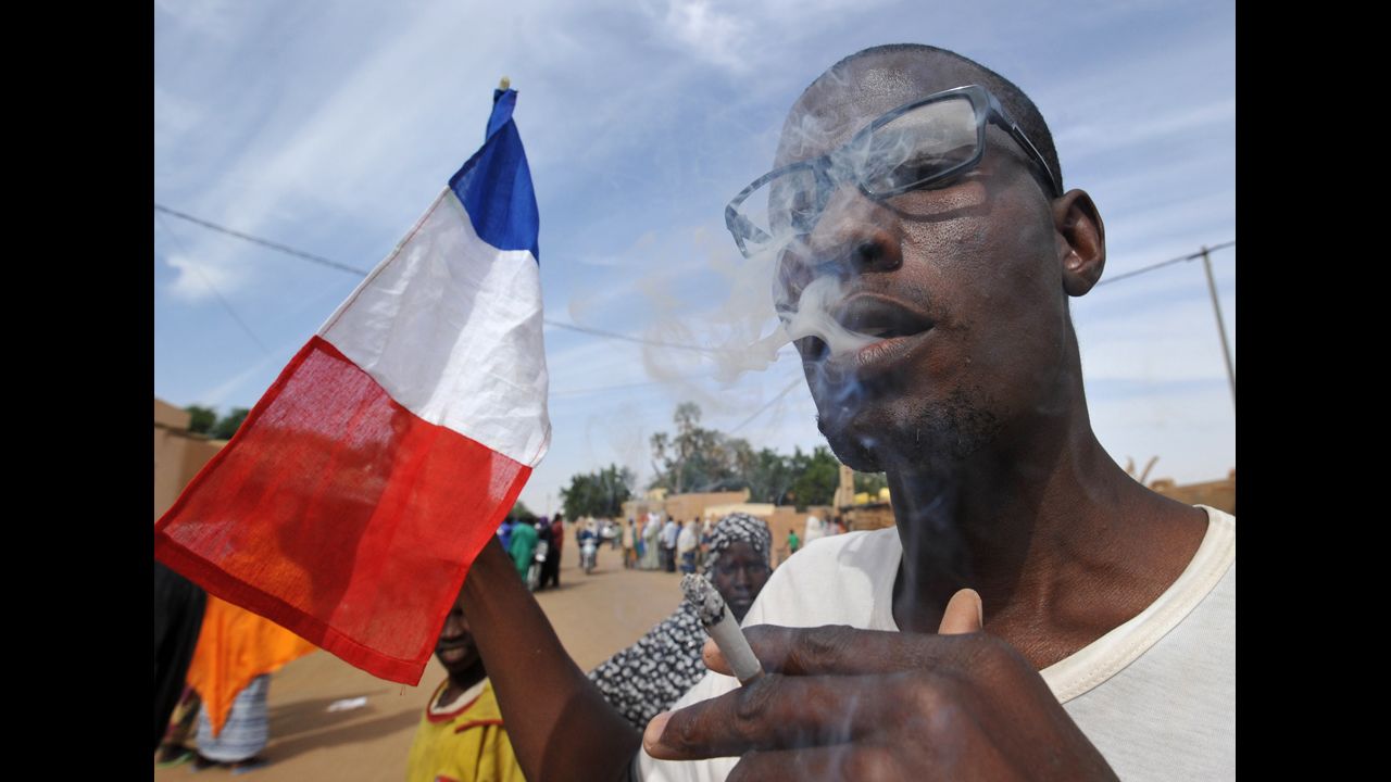 A man waves a French flag as residents celebrate the arrival of Niger troops on January 29 in Ansongo.